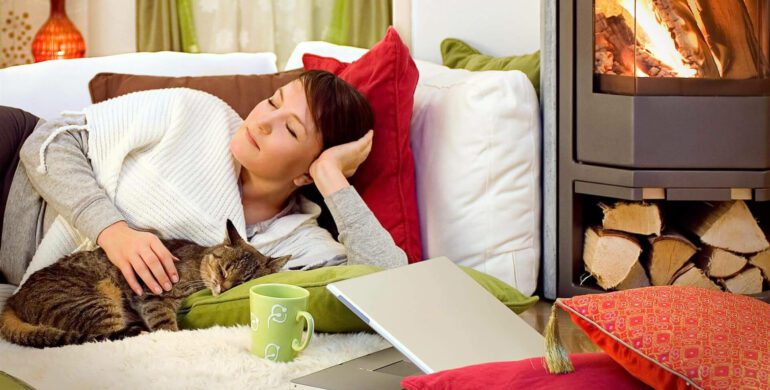 A woman laying on the bed with her cat