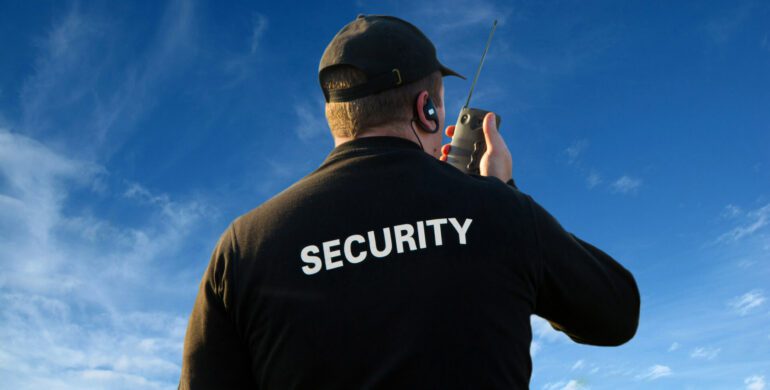 A man in black shirt holding a walkie talkie.