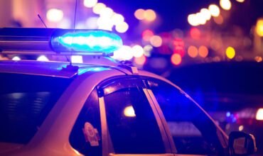 A police car with lights on the windshield.