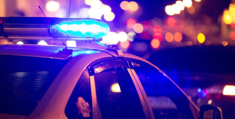 A police car with lights on the windshield.