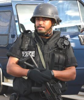 A man in black uniform holding a gun.